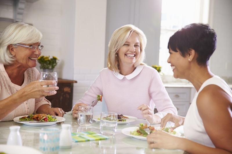 group of mature women enjoy a meal together