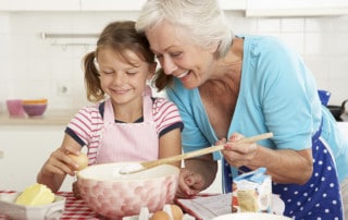 A grandmother and granddaughter baking together