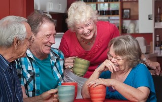 A group of old friends laughing and joking while having coffee together. They weren't looking for just any denture dentist near them, they were looking for a DFOY® dentist.