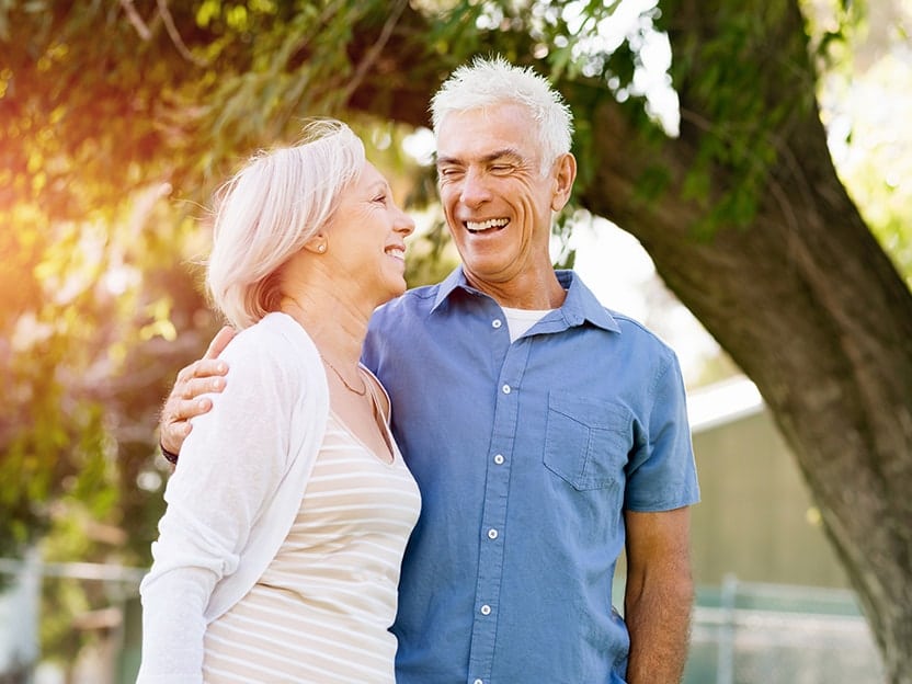 Senior couple in love, relaxing in park. The right kind of dentures can improve your love life