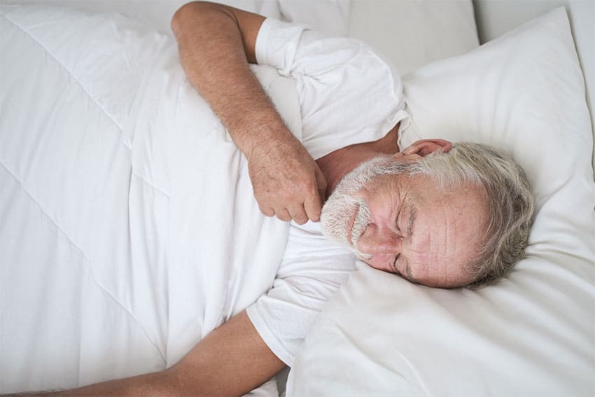 man sleeping on his back with a sore throat